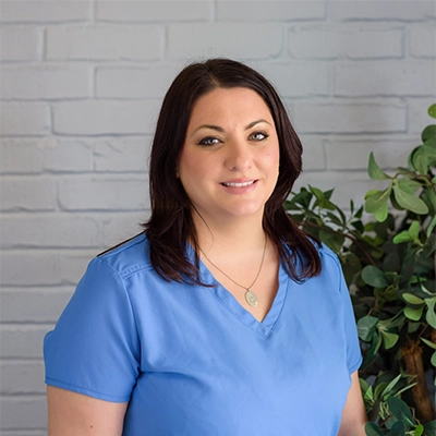 Christy Ybarra smiling while wearing light blue scrubs.