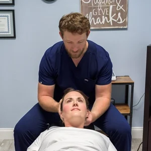 Adam Roussel Adjusting a patients neck.